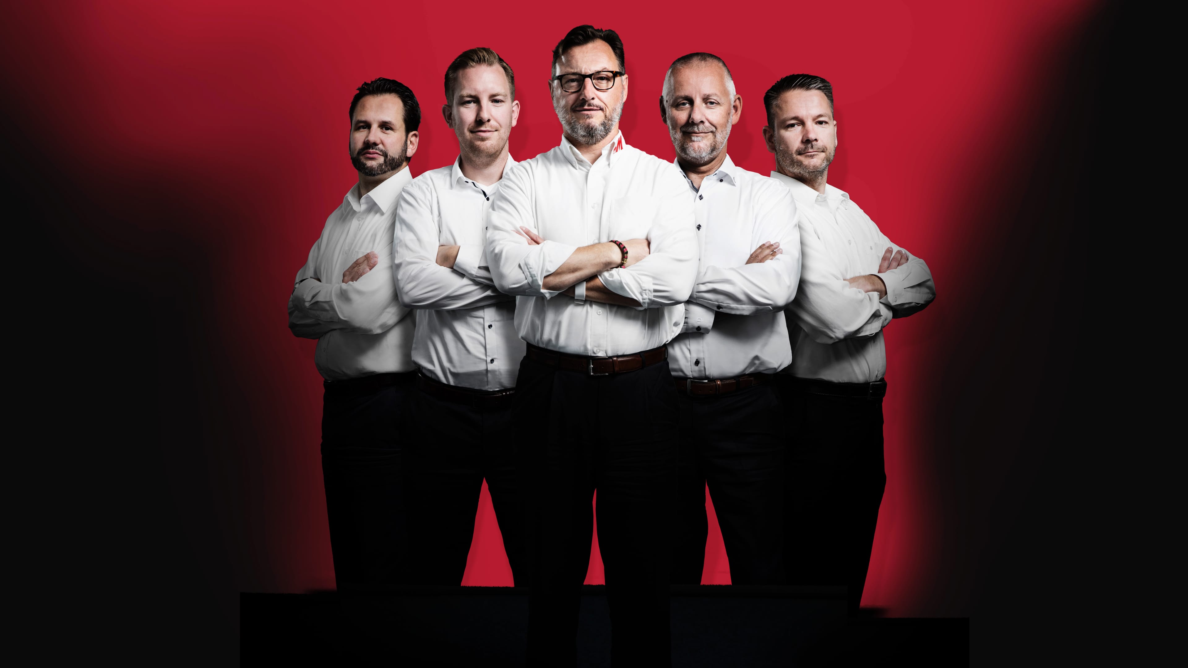 Fünf Männer in weißen Hemden posieren vor der Kamera