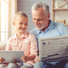 Großvater und Enkelkind lesen Zeitung