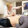 Ultraschall des Bauchs einer Schwangeren im Ringelshirt