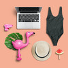 Verschiedene Gegenstände ein Badeanzug oder Strohhut auf pinken Hintergrund