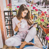 Frau im Pyjama sitzt auf einem Balkon und leist das KN E-Paper