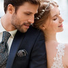 Mann im Anzug und Frau in Brautkleid stehen Rücken an Rücken
