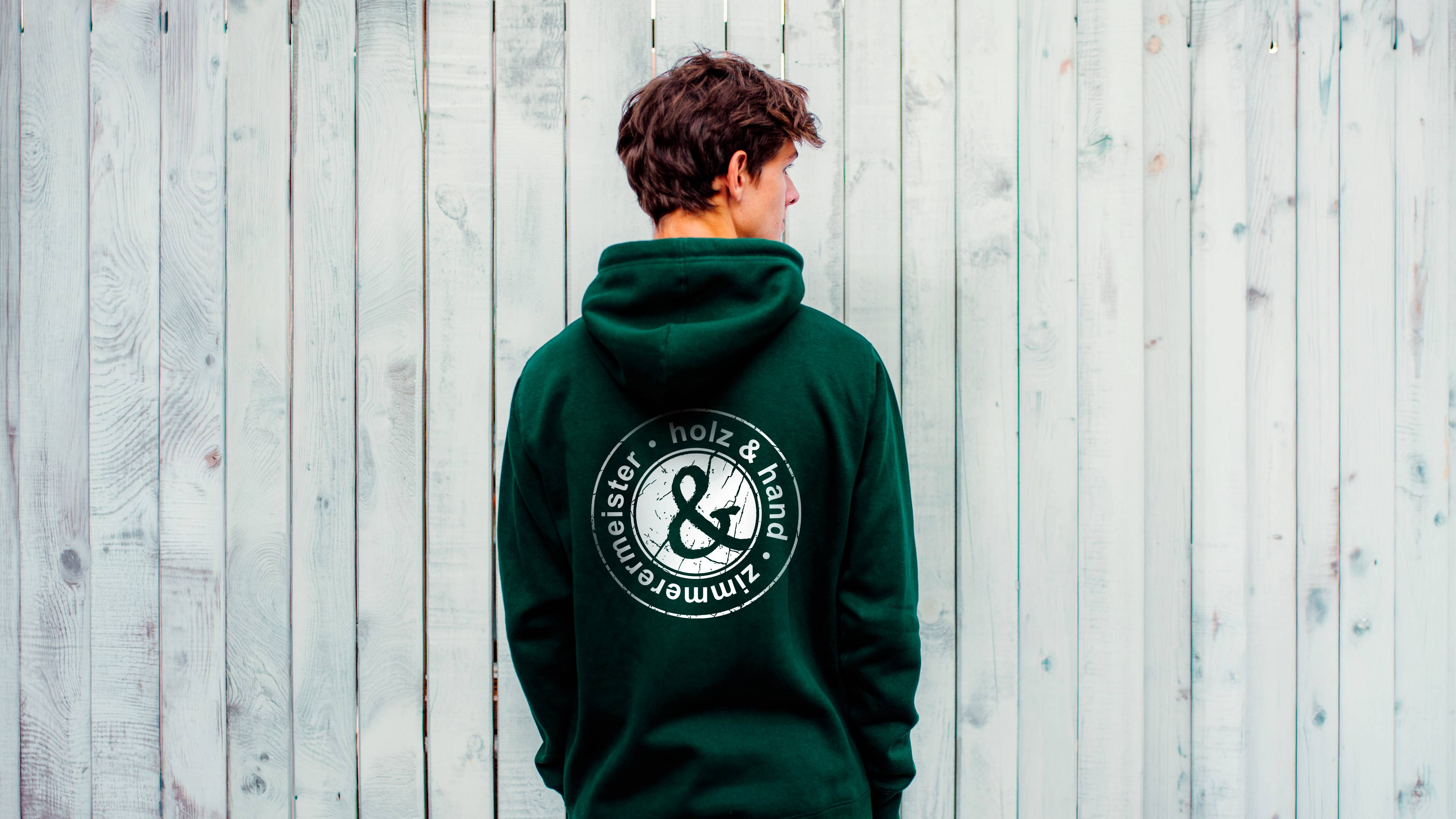Foto eines Mannes mit einem dunkelgrünen Holz und Hand Pullover