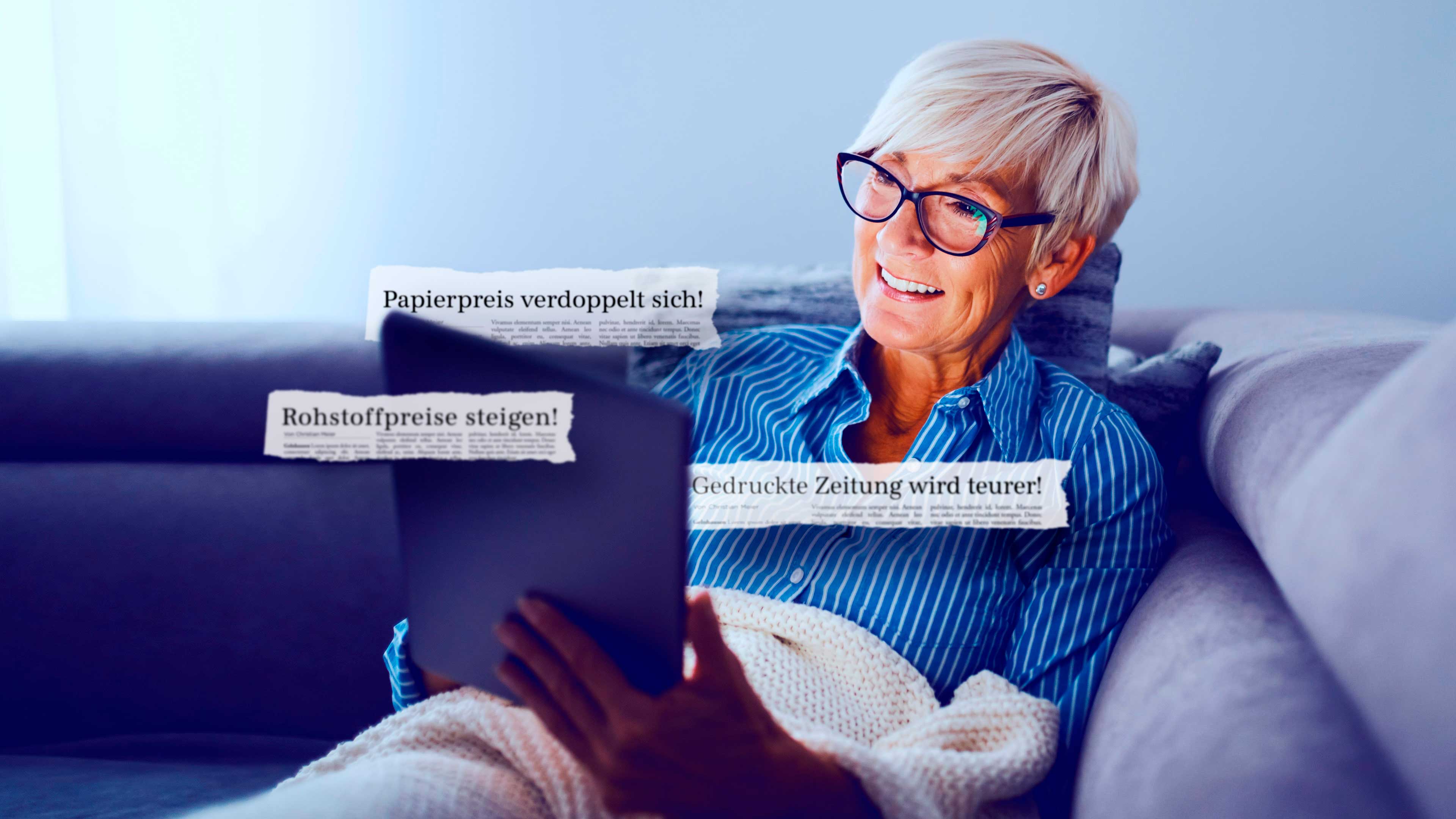Seniorin mit Tablet auf dem Sofa mit Zeitungsschnipseln "Papierpreis verdoppelt sich" und "Gedruckte Zeitung wird teurer"