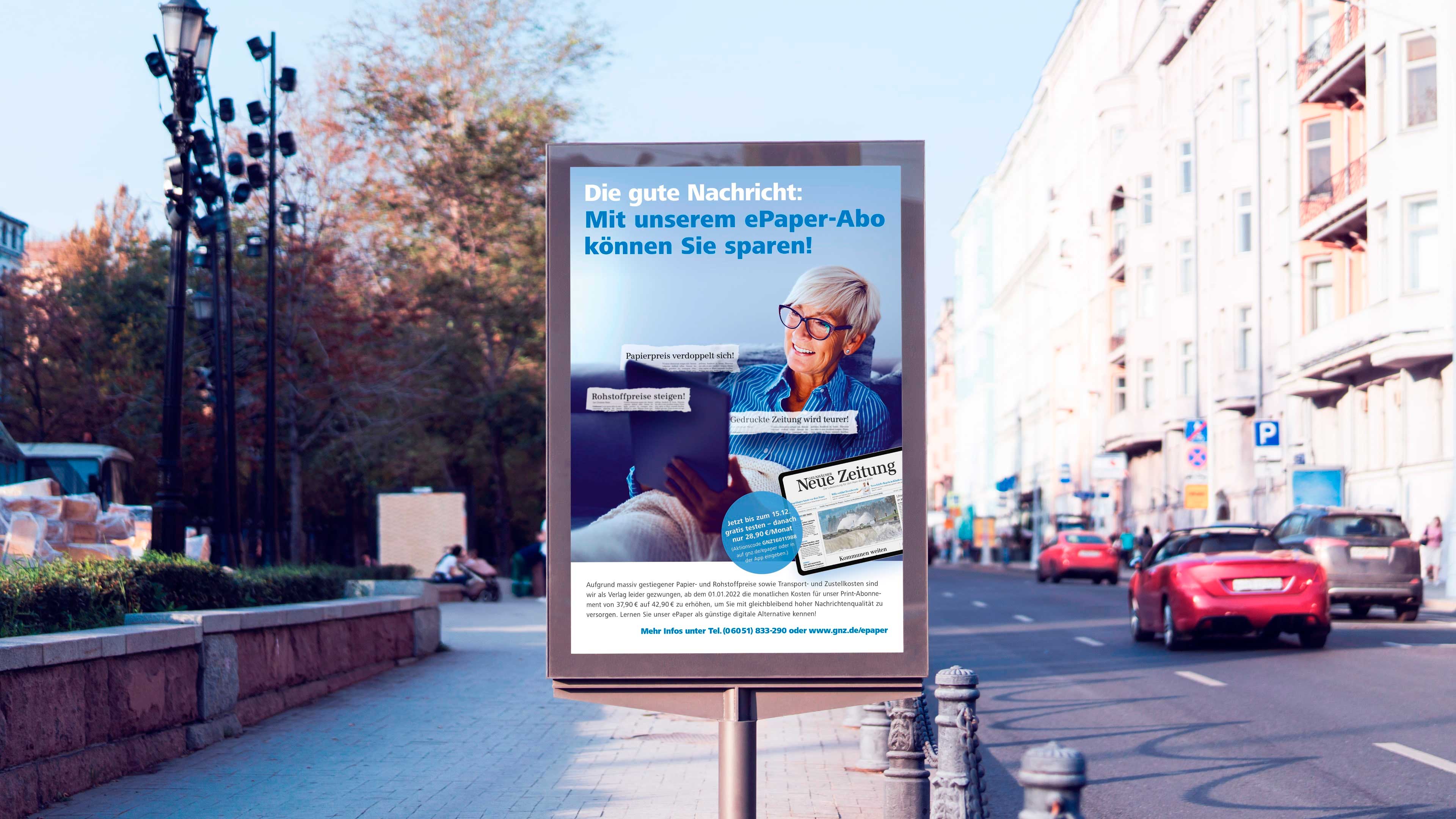 Rechteckiges Bild einer Anzeigenstele an Straße mit Seniorin und Tablet sowie Text "Die gute Nachricht: Mit unserem ePaper-Abo können Sie sparen"