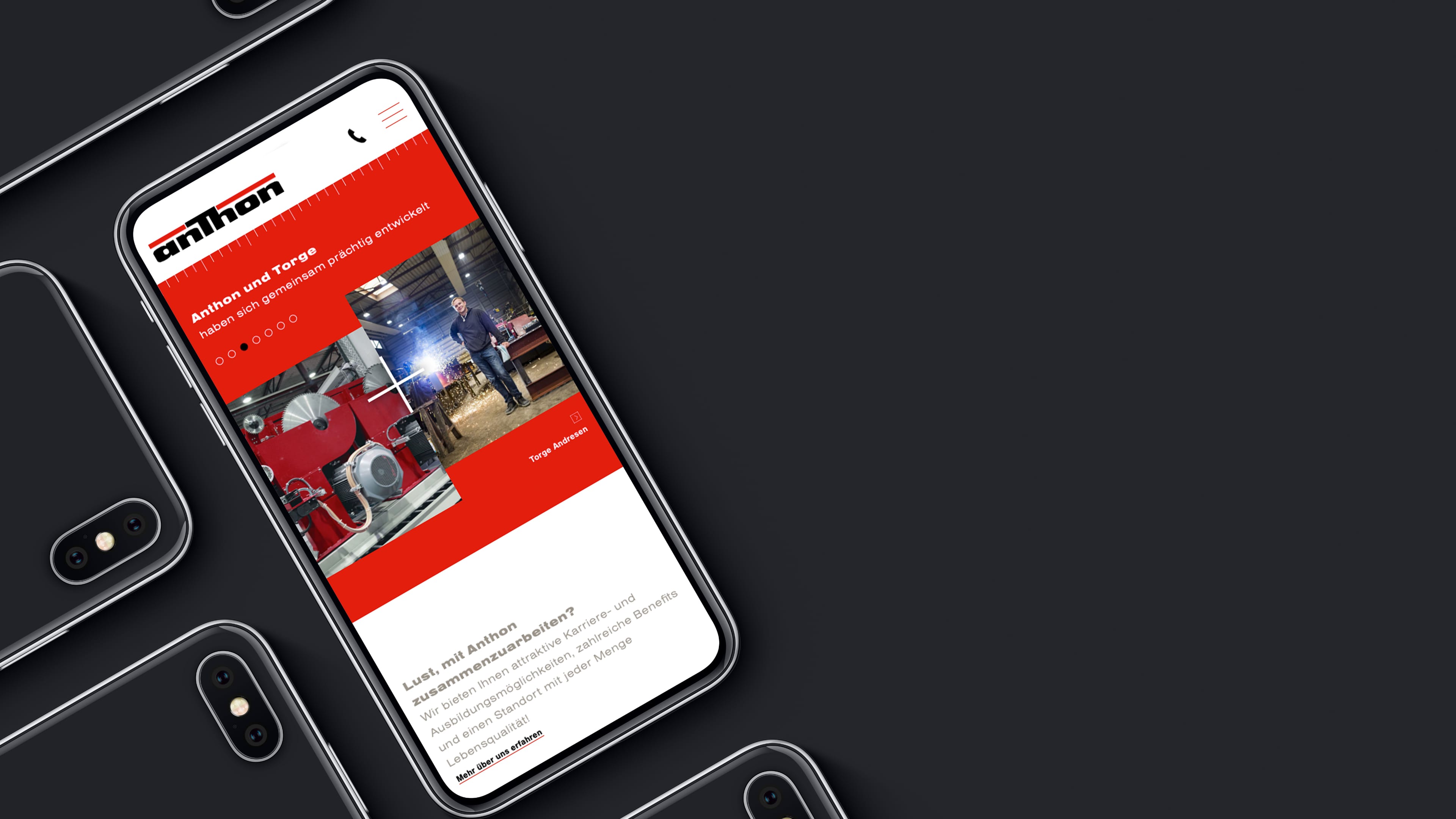Smartphone zeigt rote Website anthon.de vor schwarzem Hintergrund