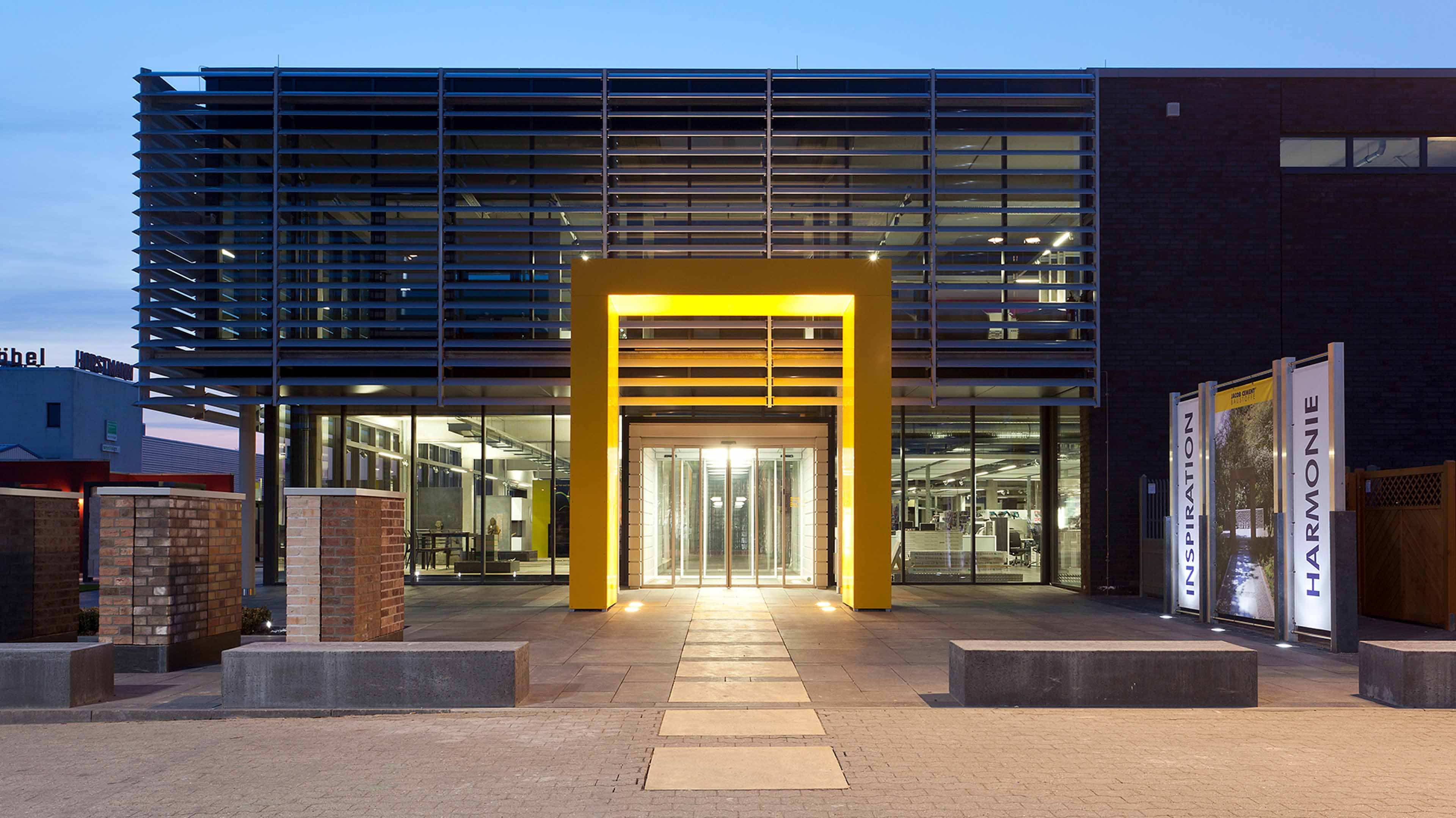 Beleuchteter Eingang zu einem großem Gebäude mit gelbem Rahmen