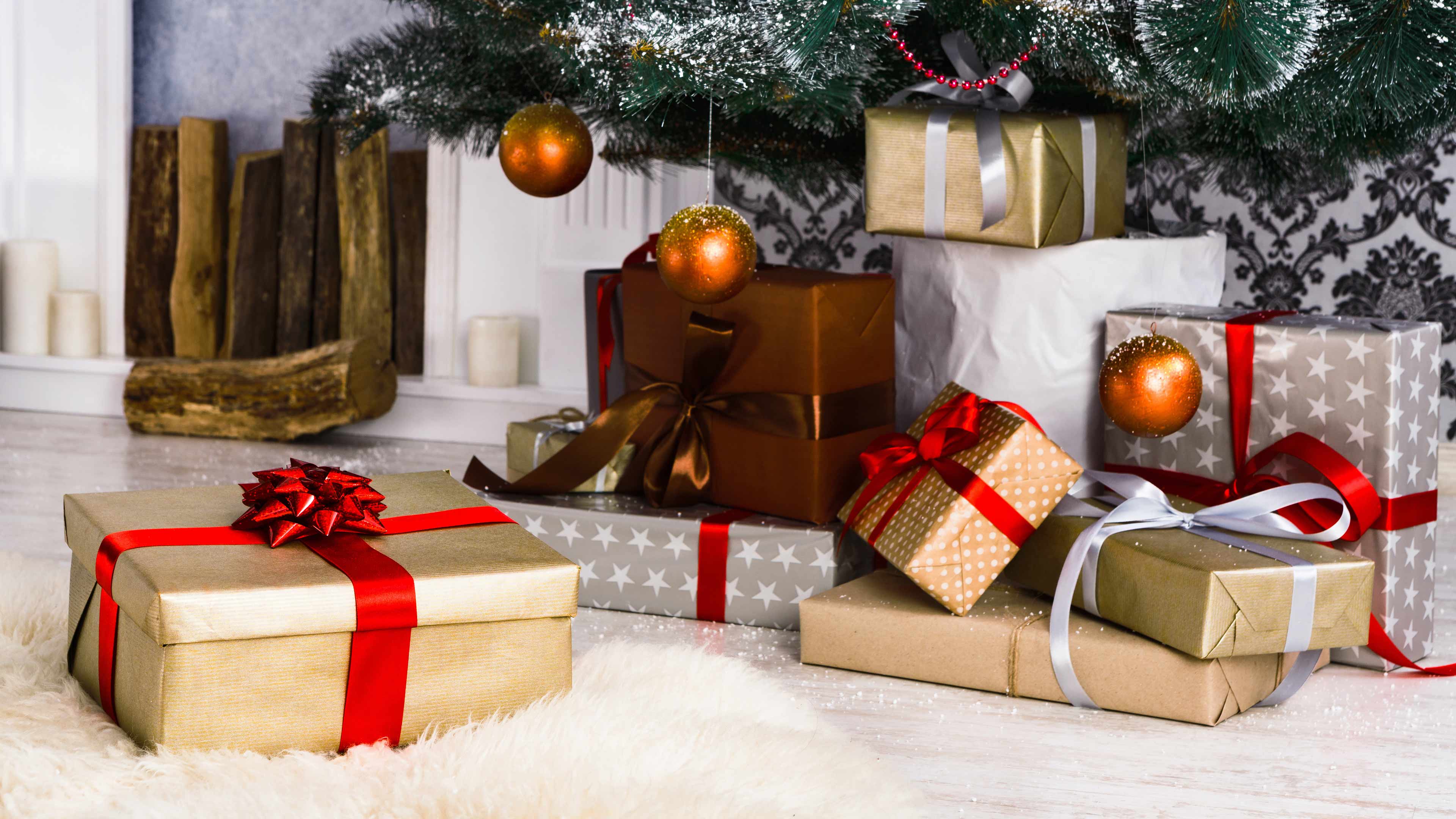 Verpackte Geschenke mit roten Schleifen unter einem Weihnachtsbaum