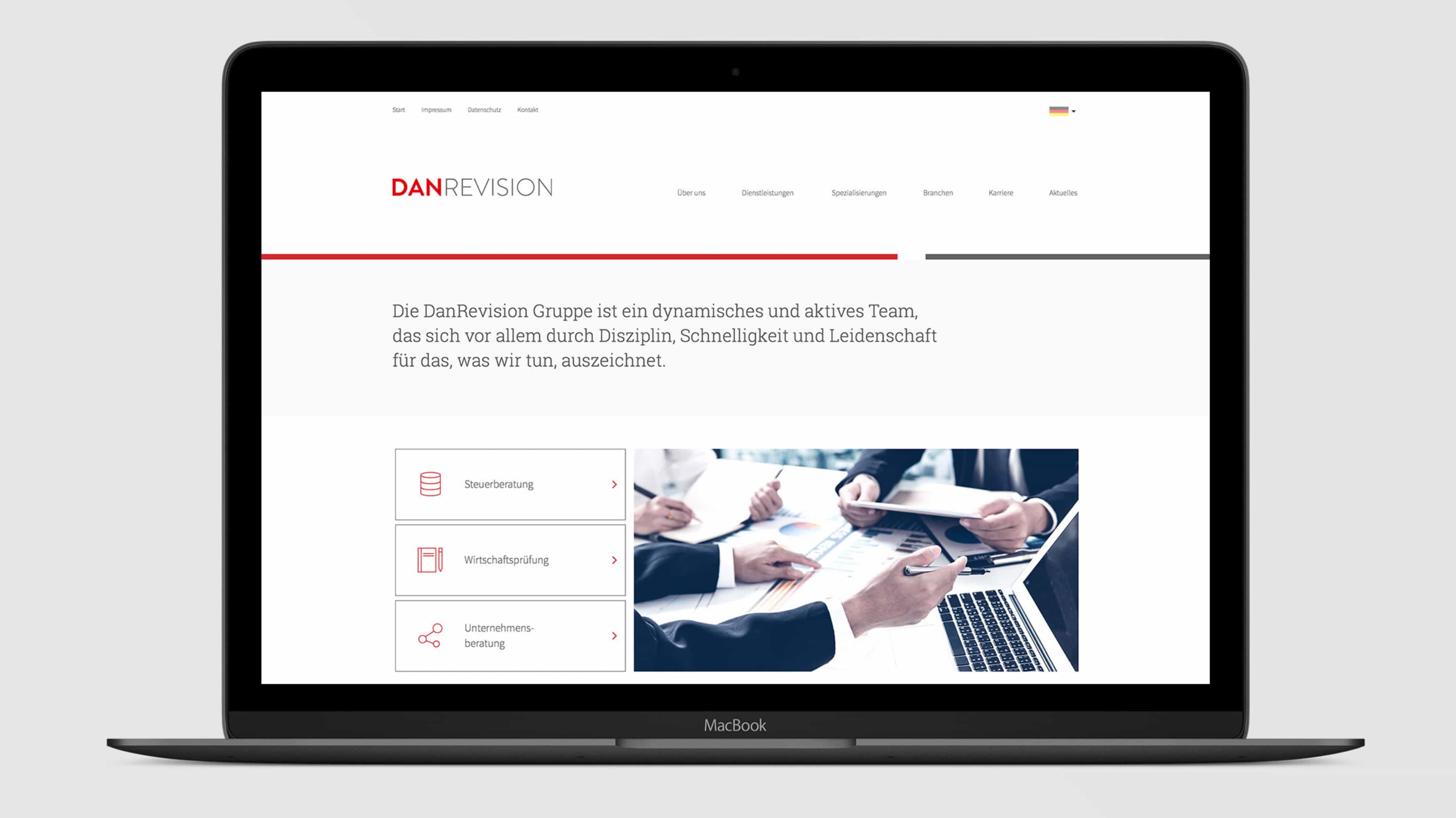 Laptop zeigt weiß-rote Startseite von DanRevision vor weißem Hintergrund