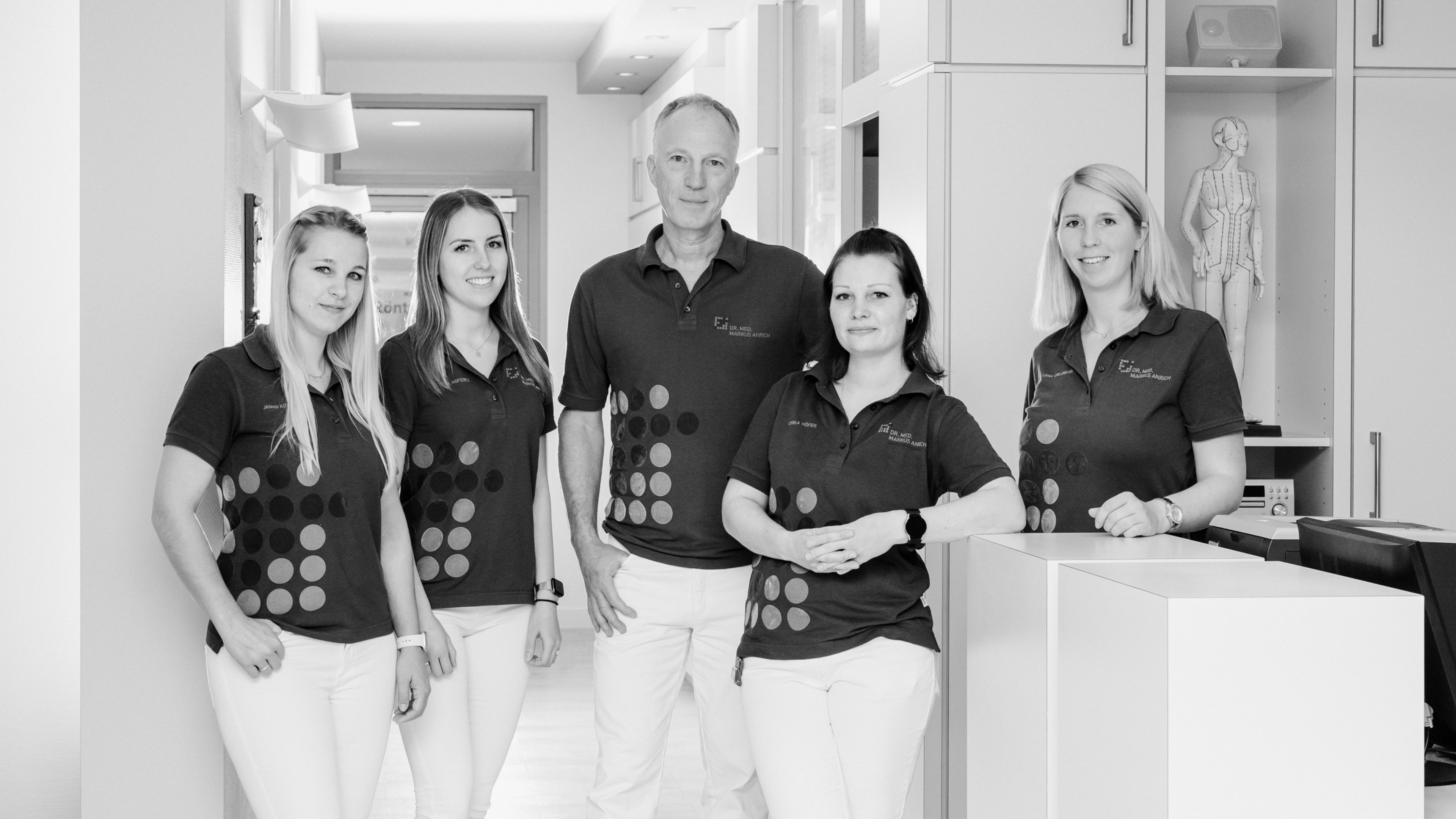 Schwarz-weiß-Aufnahme des Praxisteams mit vier weiblichen Mitarbeiterinnen und Dr. Anrich