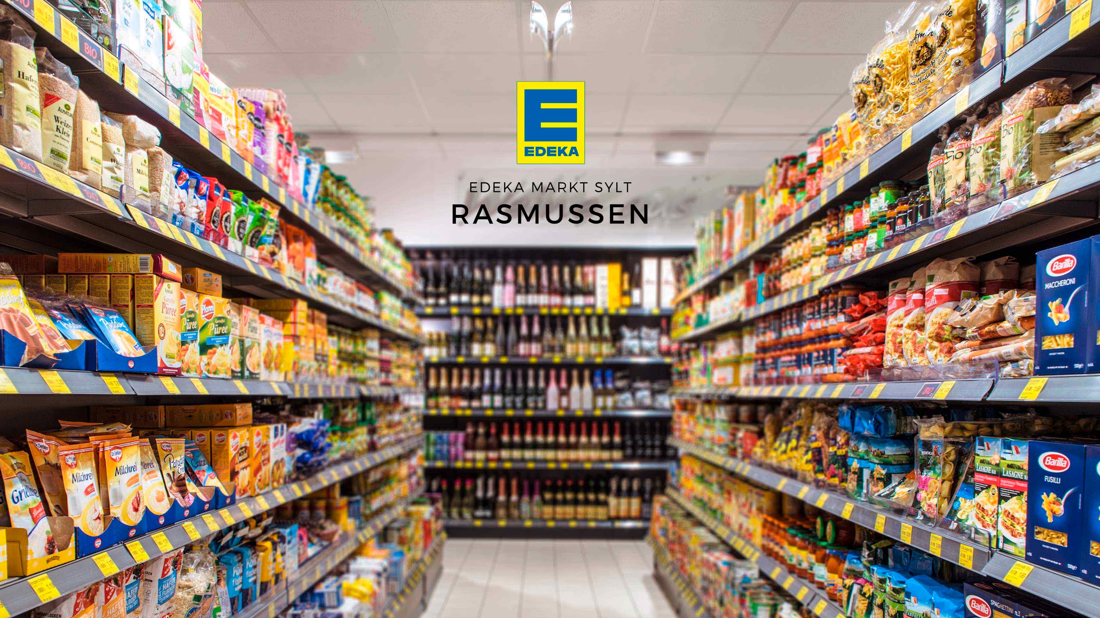 Blick durch Supermarktregale und Logo Edeka Markt Sylt Rasmussen