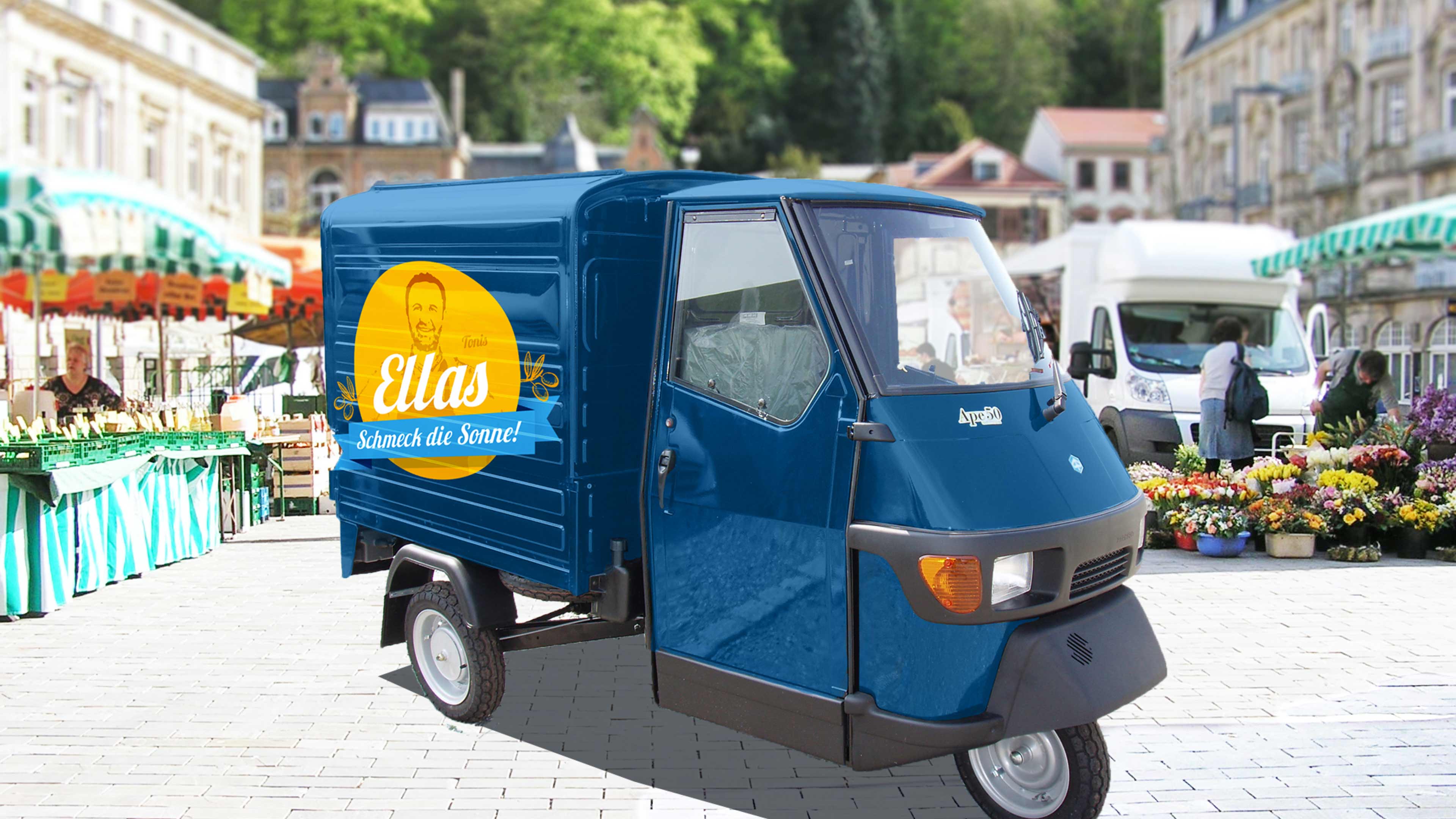 Blauer dreirädriger Kleintransporter (Ape) mit gelbem Ellas-Logo vor einem Wochenmarkt