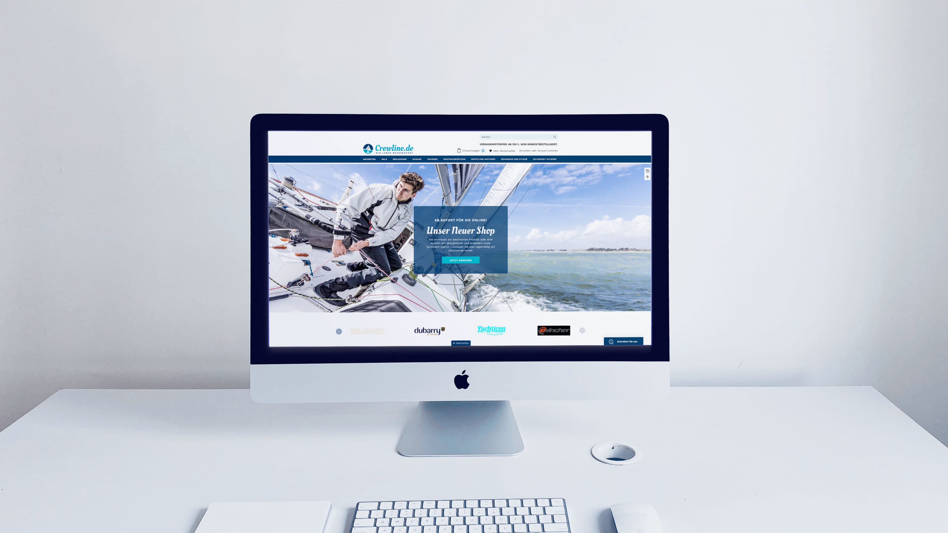 iMac auf weißem Schreibtisch zeigt Crewline.de und Text "Unser neuer Shop"