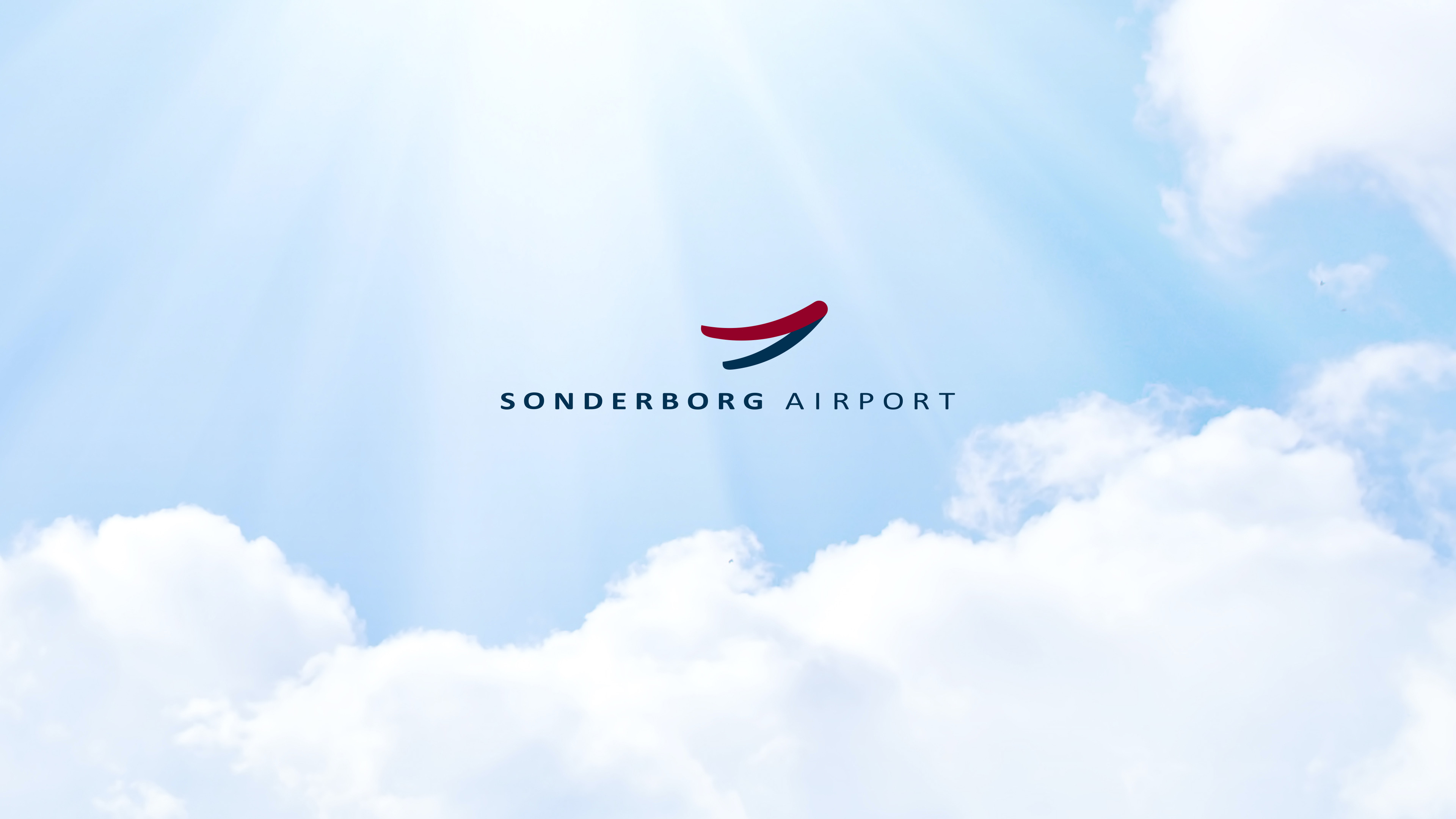 Logo Sonderborg Airport vor weißen Wolken und Sonnenstrahlen
