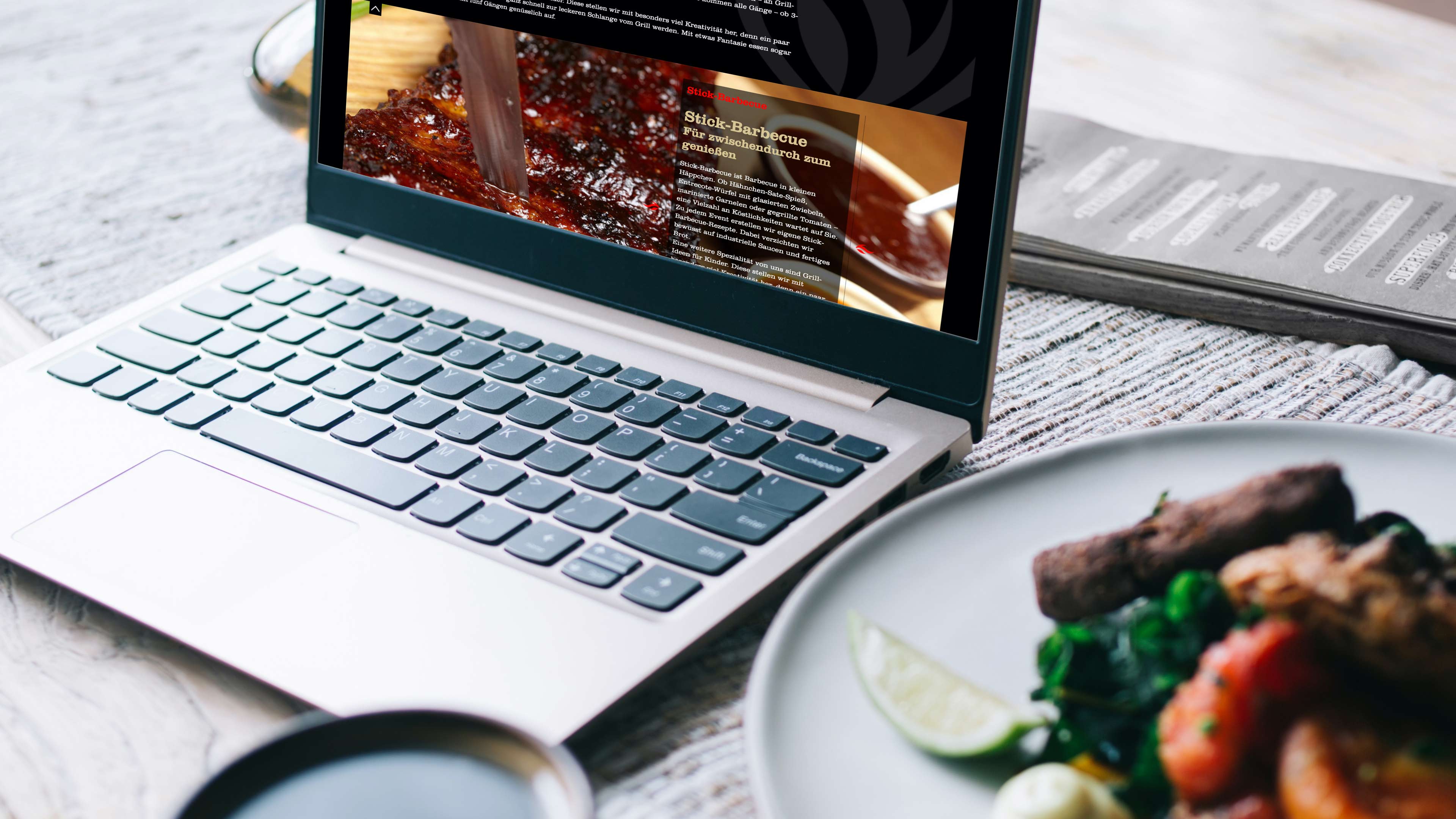 Ein BBQ Teller steht neben einem Macbook