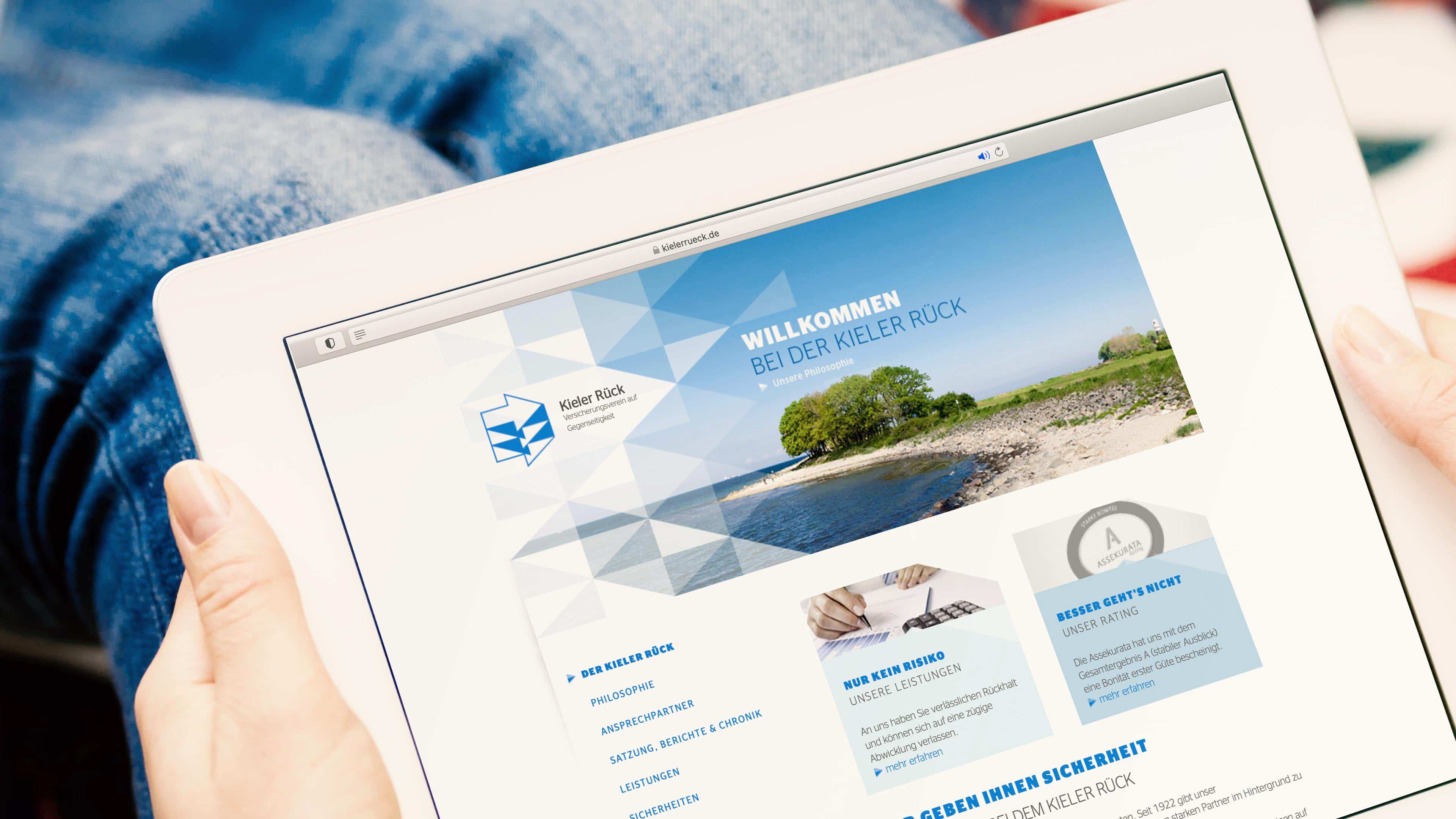 Eine Person surft mit dem Ipad auf der Kieler Rück Homepage