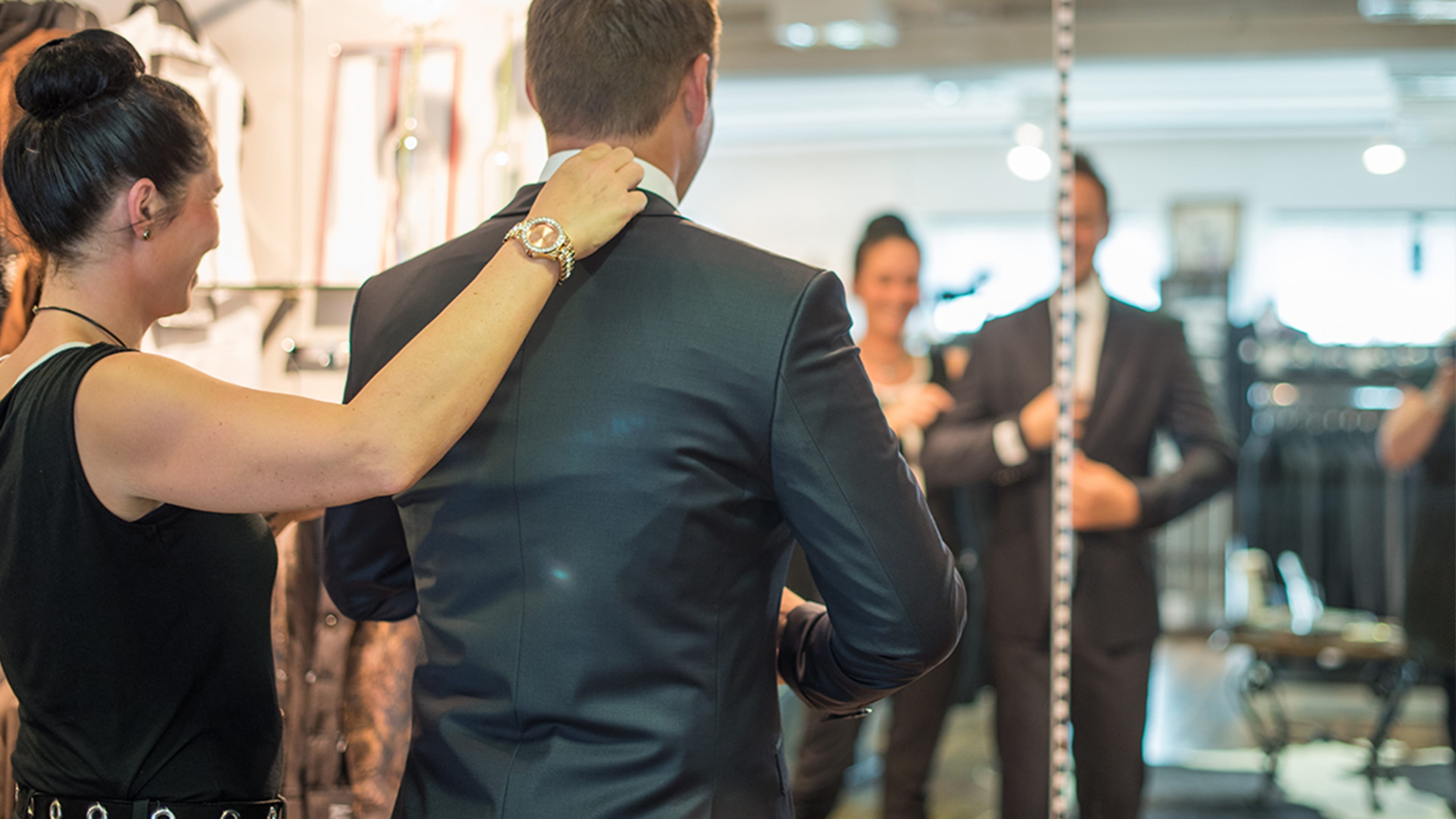 Mode Beraterin hilft einem Mann bei der Anzug Wahl