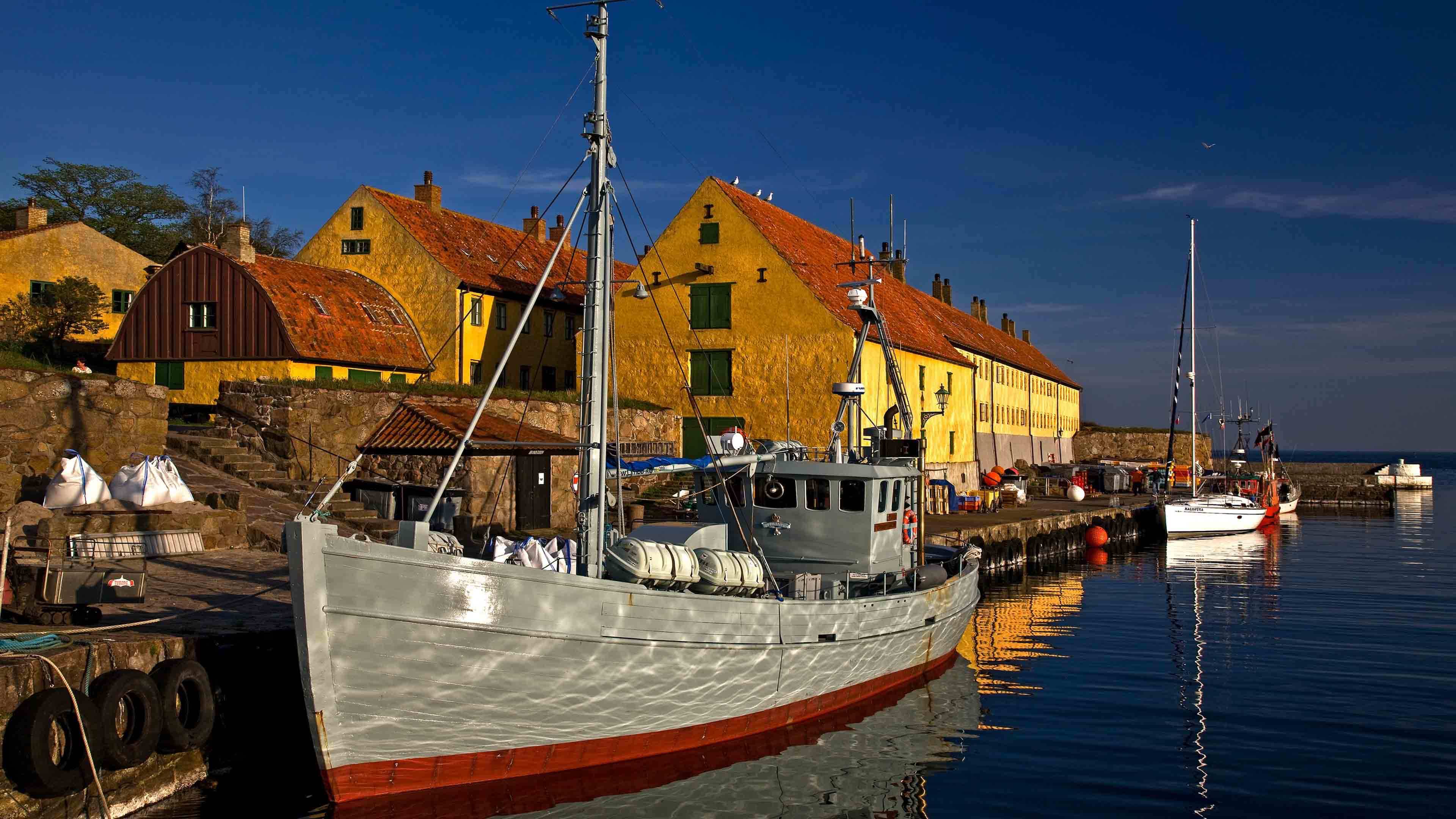 Hafen mit gelben Häusern und angelegten Booten