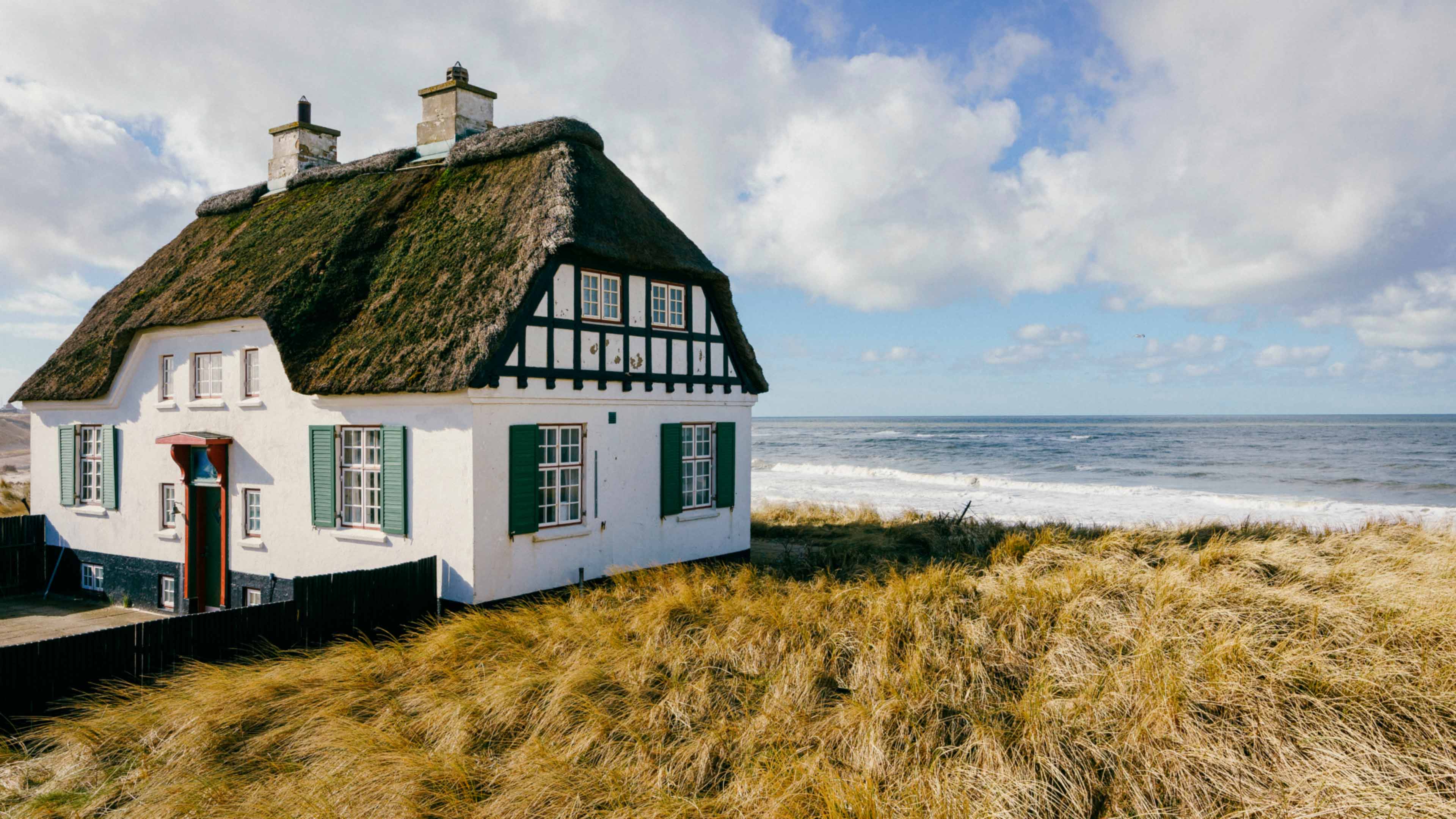 Ein weißes Reetdachhaus am Strand