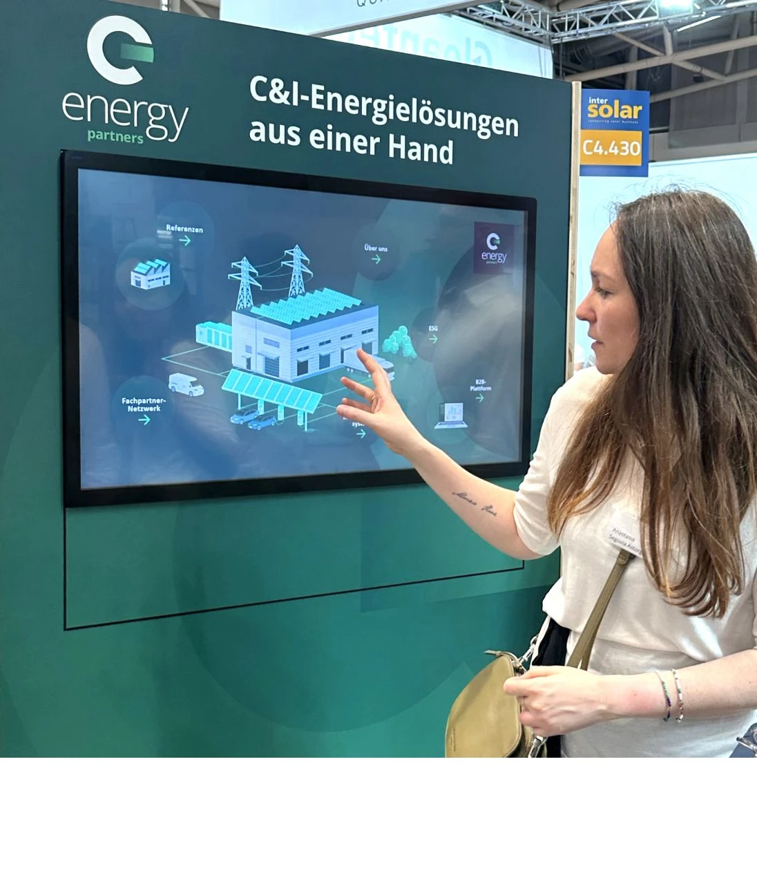 h2_messe_teaser_04.jpg Eine Messebesucherin an einem Touch-Display der Firma Energy Partners