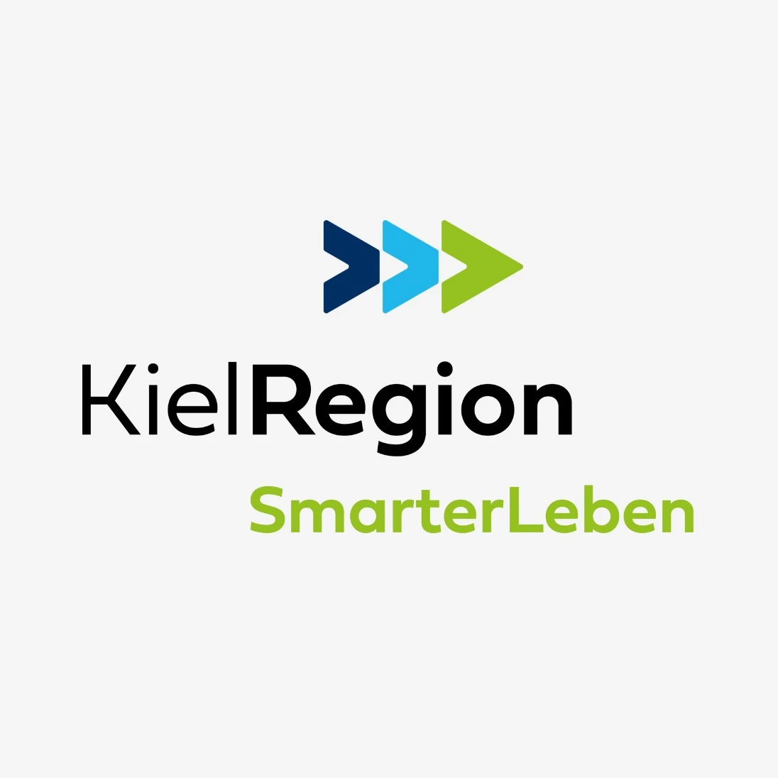 Der Schriftzug Kielregion in schwarz auf weiß, darunter Smarter Leben in hellgrün und oben drei Pfeile nach rechts in dunkelblau, hellblau und hellgrün.