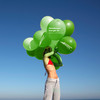 Frau im Bikini hält grüne Ballons
