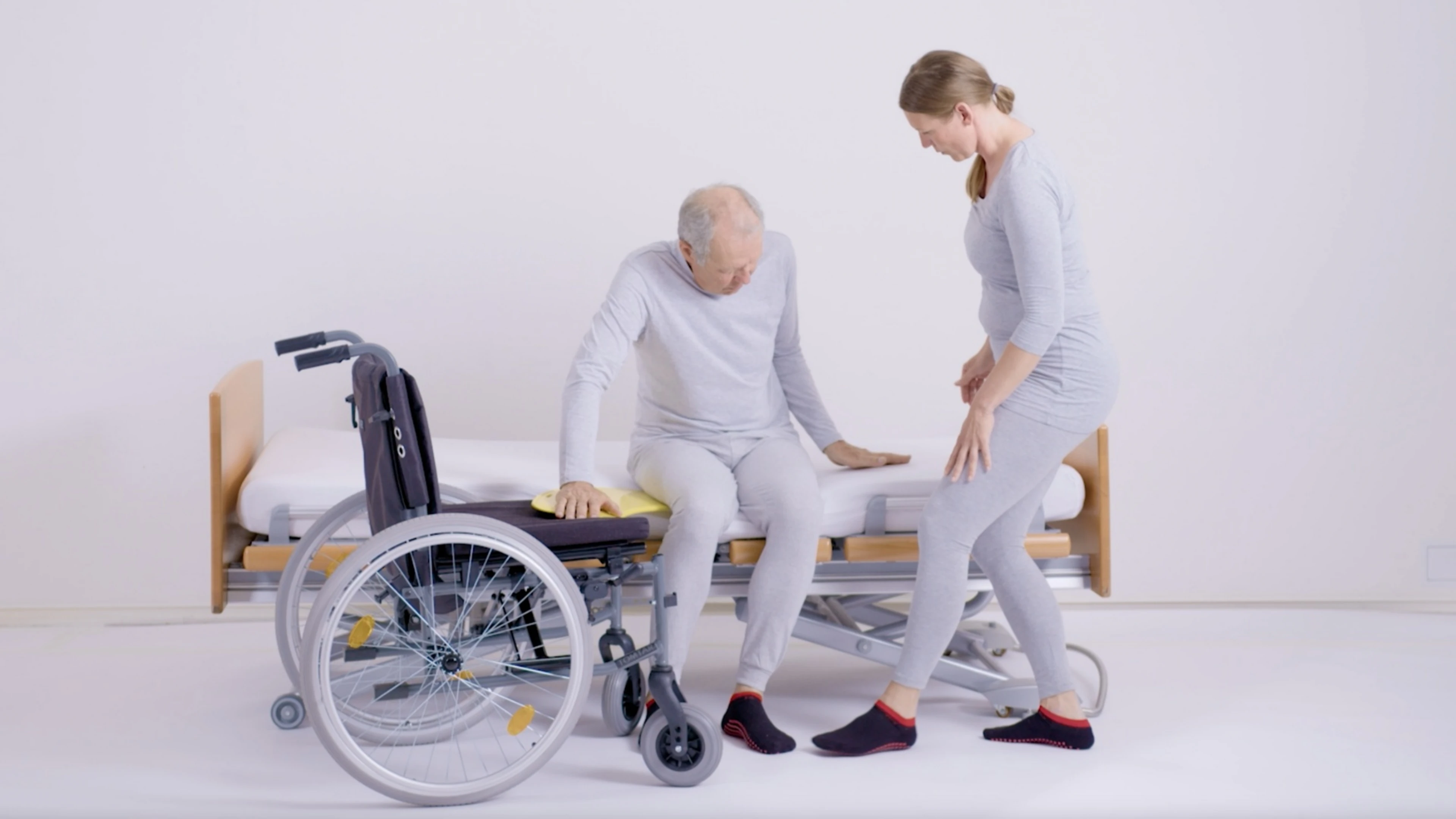 Eine Pflegerin von Kinaesthetics macht Übungen mit einem Patienten