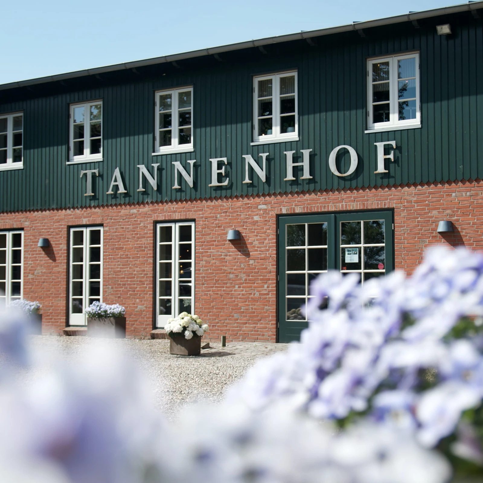hochzwei_tann_teaser_03.jpg Grün rotes Backstein Gebäude vom Tannenhof