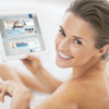 Eine Frau sitzt in der Badewanne und surft auf der Friedrich Lange Homepage