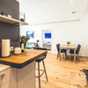 Kleine Küchenzeile und Sitzgruppe in einer Wohnung mit hellem Holzfußboden