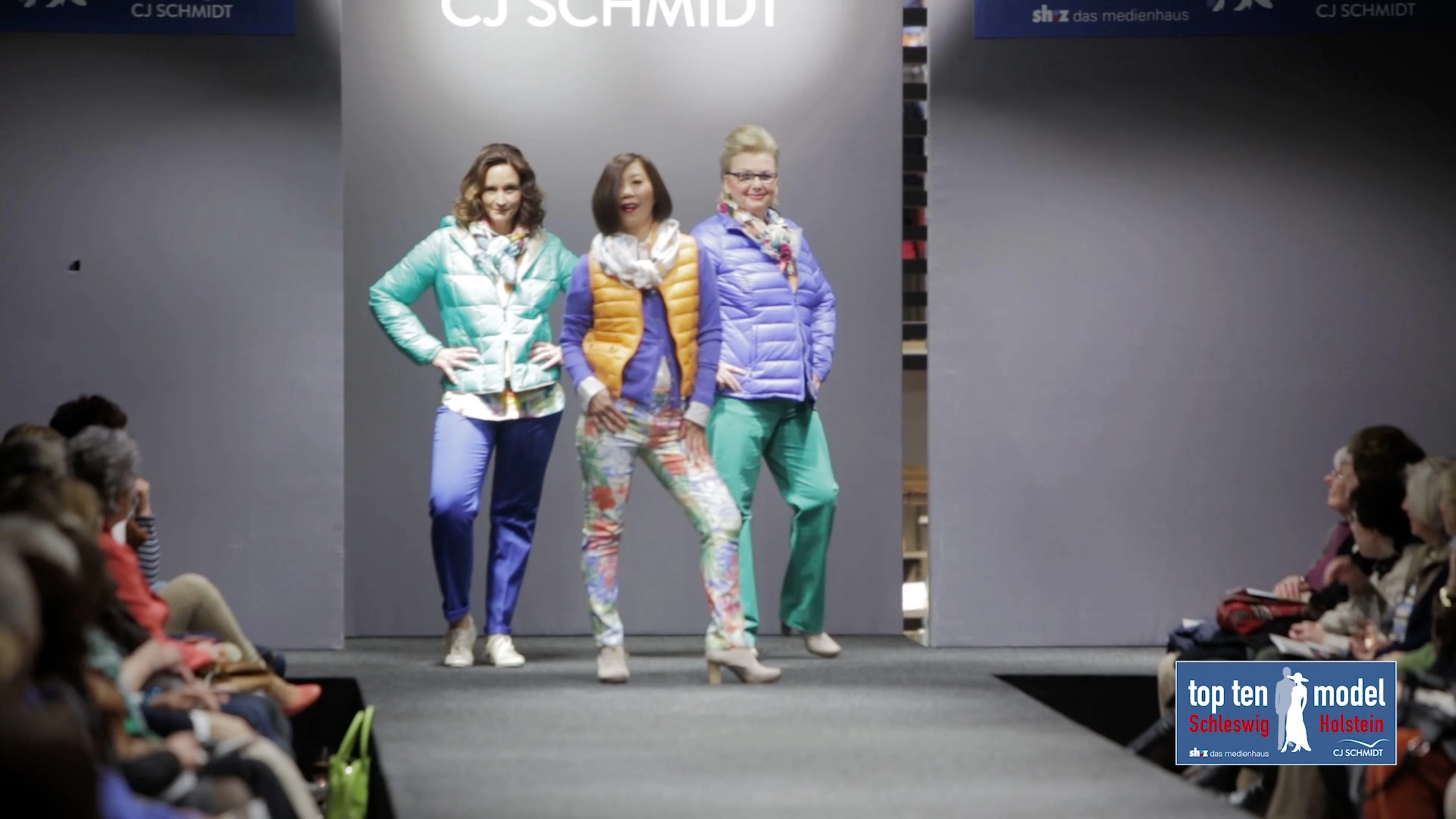 Drei Models posieren in bunten Outfits vor der Kamera