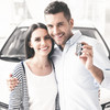 Mann im weißen Hemd hält Frau und hält Autoschlüssel in der Hand