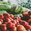 Rote Tomaten, dahinter grünes Gemüse