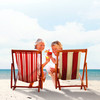 Zwei ältere Personen sitzen in Strandstühlen