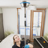 Frau reinigt Sprenkleranlage an Zimmerdecke