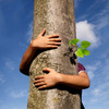 Eine Junge umarmt einen Baumstamm
