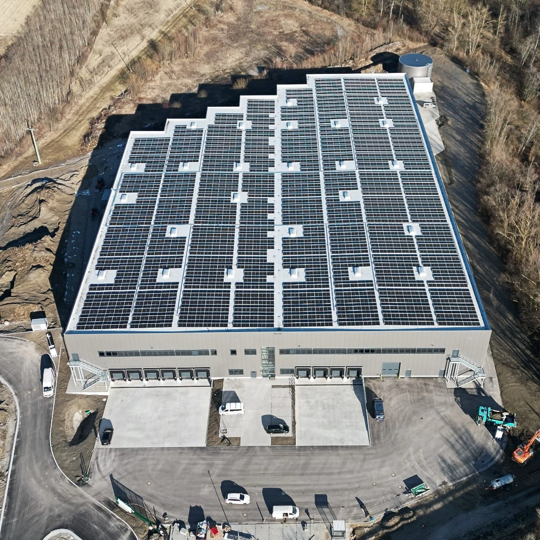 Luftaufnahme einer Halle mit Solarpaneelen