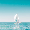Weißes Segelboot spiegelt sich im Wasser