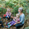 Eine Kindergärtnerin ist im Wald mit zwei Mädchen