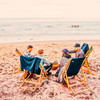 Vier Personen sitzen in Klappstühlen am Strand