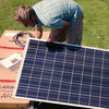 Ein Mann baut ein Solarmodul auf