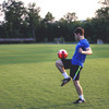 Fussballer im blauen Trikot spielt mit rotem Ball