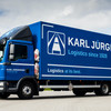 Ein blauer LKW von Karl Jürgensen steht auf einem Parkplatz