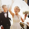 Lachendes Brautpaar mit Blumenstrauß und Schleier