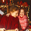Blonde Frau und kleines Mädchen in roten Weihnachtspullis