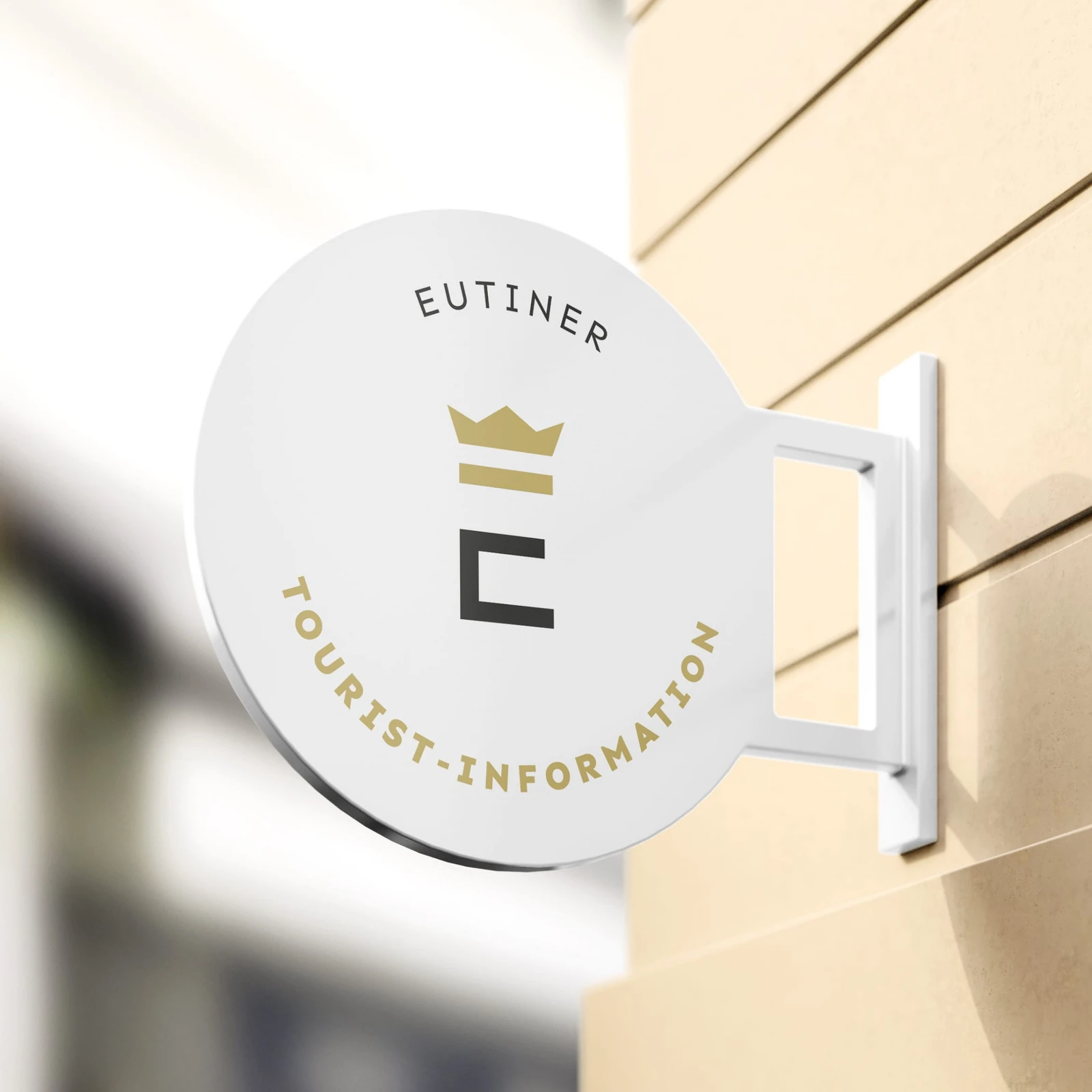 Rundes Logoschild an Hausfassade mit Text 