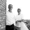 Schwarz-weißes Foto von zwei Herren mit Brille im weißem Hemd