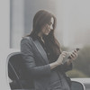 Geschäftsfrau mit langen Haaren schaut auf ihr Smartphone
