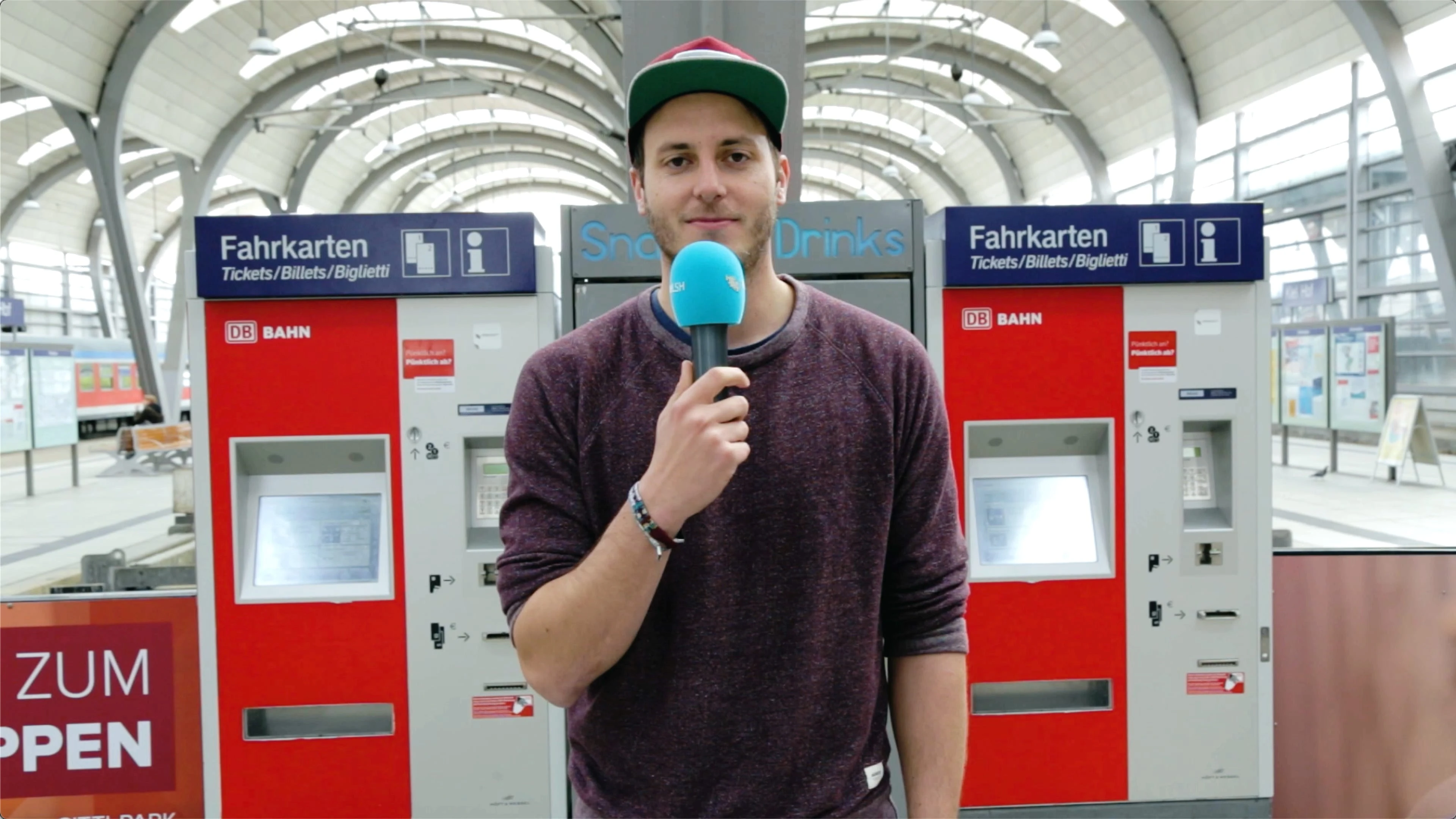 Lars steht vor zwei Ticketautomaten