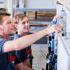 Zwei Mitarbeiter der anthon GmbH stellen lächelnd eine Maschine ein